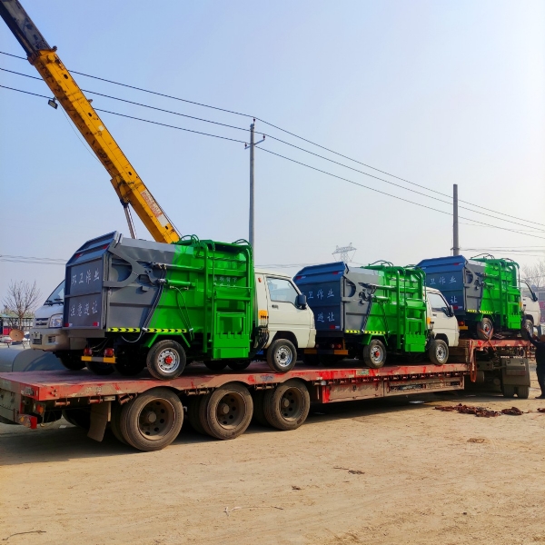 十二輛掛桶垃圾車裝車中，準備發往哈爾濱